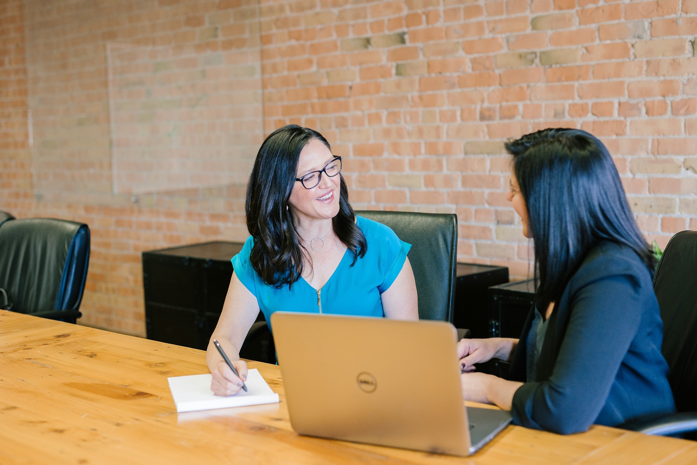 Two executives in conversation at a meeting table